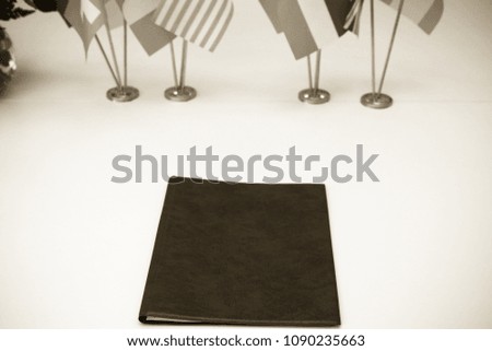 Flags of different countries on the background of the white table. Selective focus. Shallow depth of field. Toned.