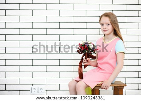 little girl is sitting on a chair and posing on the camera
