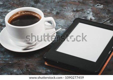 E-book and paper books on the table with a cup of coffee, a laptop and reading glasses. Concepts of self-education.