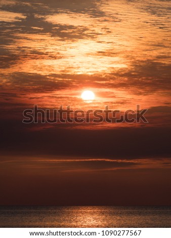 Vivid tropical sunset - red sky over calm ocean