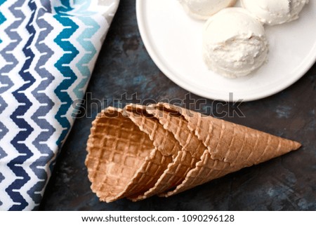 Ice cream balls, scoops and waffle cones on dark background. Advertising space.