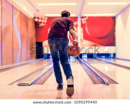Boy about to roll a bowling ball hobby and leisure concept