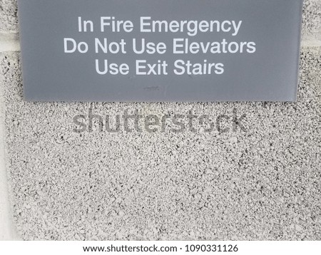 grey in fire emergency do not use elevators sign on wall