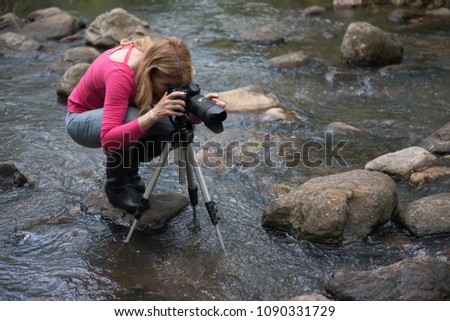Woman with dslr camera and tripod