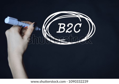 The businessman writes an inscription with a white marker:B2C
