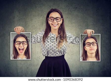Happy woman holding two different face emotion masks of herself Royalty-Free Stock Photo #1090368392