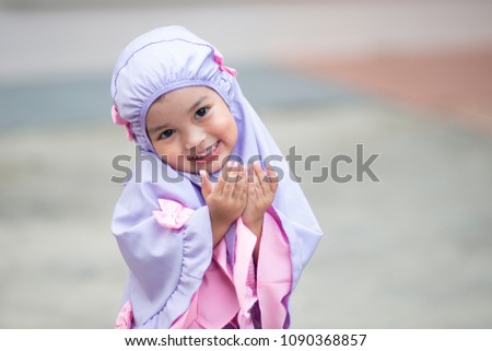 Muslim kid girl wearing Hijab praying Dua during Ramadan period. The concept is Islam,Dua,religion,worship and sin. Royalty-Free Stock Photo #1090368857