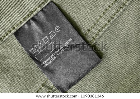 Composition and care clothes label on khaki textile background closeup