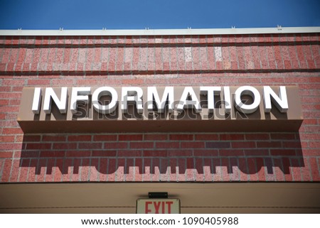 information sign on a brick building over an exit sign