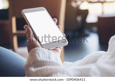 Mockup image of hands holding white mobile phone with blank desktop screen