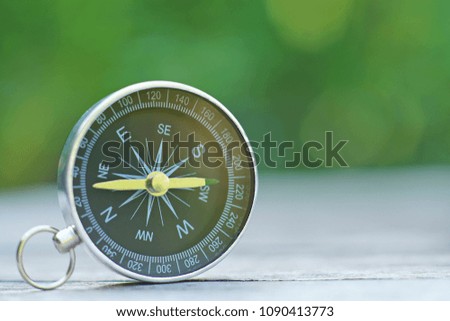 Compass with smooth blur green background, journey planning concept