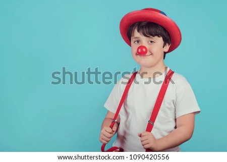 funny child with clown nose on blue background