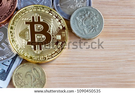 Bitcoin, British one pound, and euro coins on wooden table background.  Virtual money and cryptocurrency concept.
