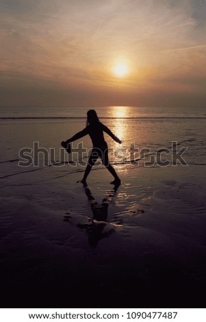 backlight photo of a girl silhouette in sunset at the beach in the Netherlands