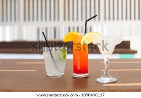 Cocktail glasses on wooden background. Margarita, tequila sunrise, mojito