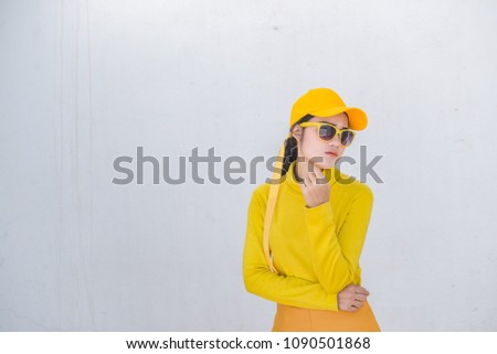 Portrait of beautiful asian woman in yellow cloths on dirty white wall,Hipsters girl wear yellow hat  take a picture,Thailand people