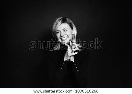 Close up portrait of a young business woman, laughing and looking to the side, against a plain studio background