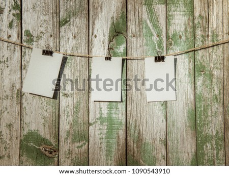 Empty sheets of paper hanging on a rope on a wooden background. Note Papers on the wood background