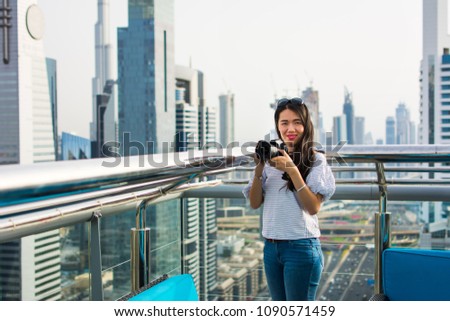 Female photographer taking picture of Dubai cityscape