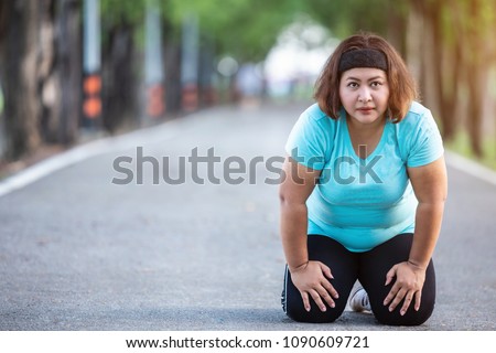 Exercise and healthy concept : Fat woman feeling tired while running in the park Royalty-Free Stock Photo #1090609721