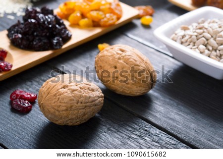 sun dried super foods, nuts and cereals on black wood table background