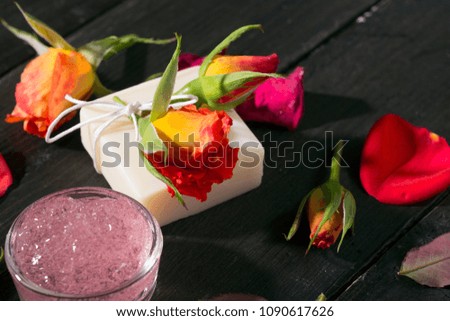 beauty products with roses on black wooden