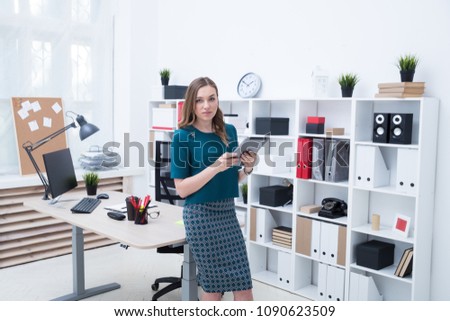 Business woman typing on tablet in office
