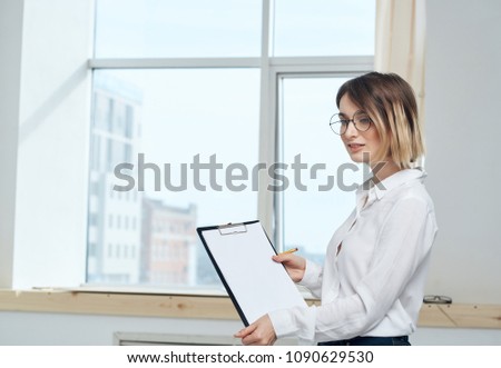 woman with a folder for documents is at the window                              