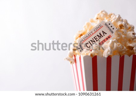 Cinema moments concept with popcorn and movie tickets on white background. Horizontal composition. Front view.