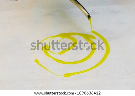 Pouring olive oil on grease proof paper  Royalty-Free Stock Photo #1090636412