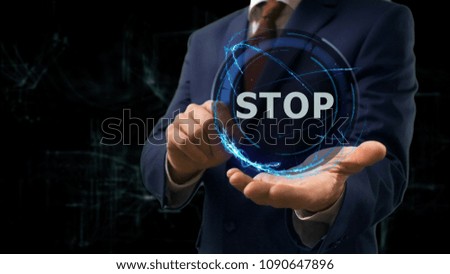 Businessman shows concept hologram Stop on his hand. Man in business suit with future technology screen and modern cosmic background