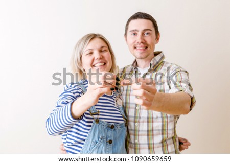Image of woman and man with keys from apartment against blank wall