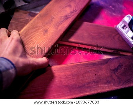 close up man's hand working with wooden bars in the workshop