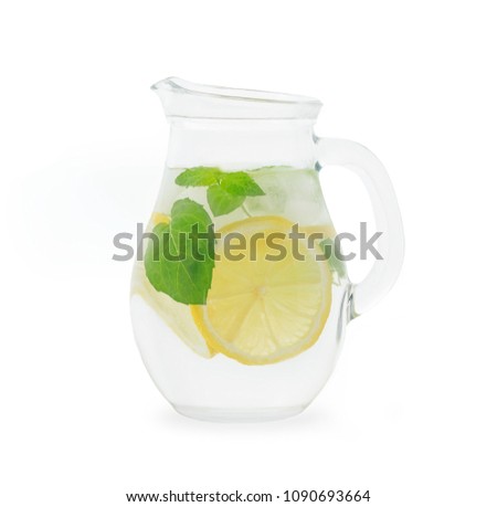 Glass jug of cold lemonade on white isolated background. Pitcher lemon water with mint. Jar of cold lemonade