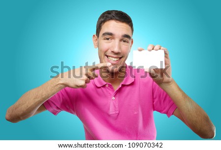 Young man holding a white card over light blue gradient background
