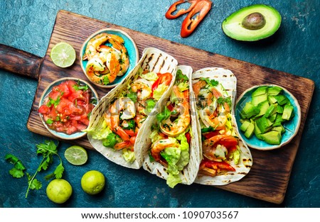 Shrimps tacos with salsa, vegetables and avocado. Mexican food.