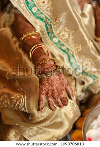 close up of bride with henna tattoo and gold bracelets 