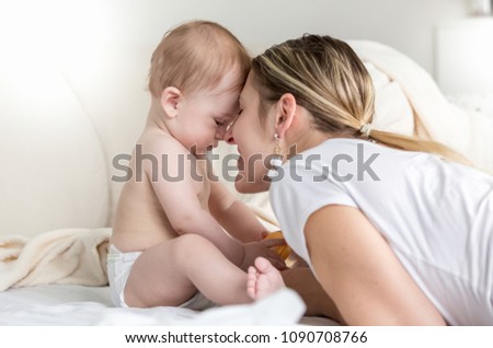 Portrait of beautiful woman loving her baby son looking at him