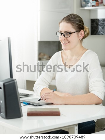 Portrait of smiling female graphic designer working at modern office