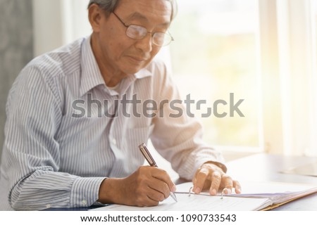 Asian senior working hand writing or sign insurance contract for future concept.