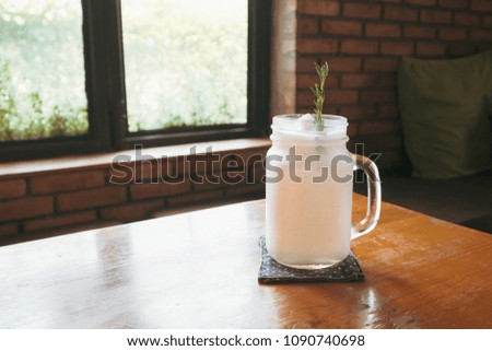 fresh coconut water frappe with rosemary leaf on restaurant table