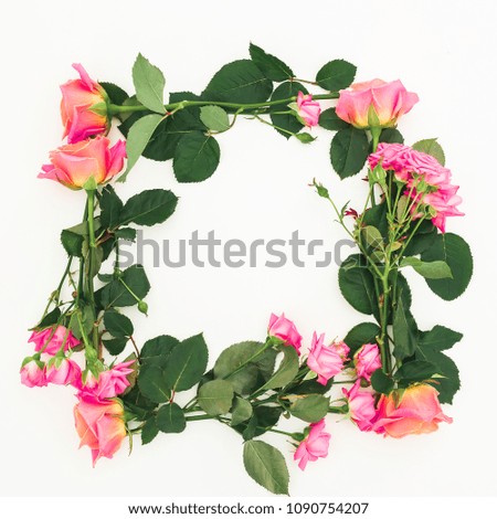 Floral frame of roses flowers, buds and green leaves on white background. Flat lay, top view. Spring background