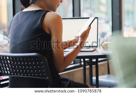 female holding and look at phone in coffee shop