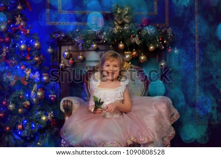 girl in white with pink dress sitting in chair near Christmas tree in Christmas