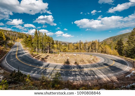 Highway with hairpin turn (switchback) at autumn sunny day in Rocky Mountain National Park. Colorado, USA.  Royalty-Free Stock Photo #1090808846