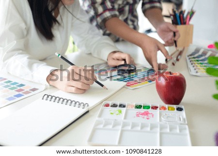 Graphic designer using color swatch to do his work at modern office. Architect using work tools and sample colour catalog. 