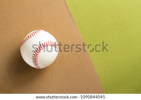 Rigid baseball ball and green and brown background