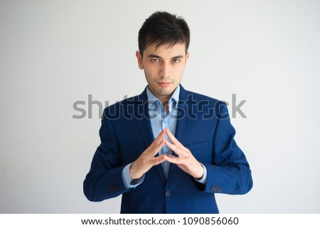 Serious business man holding hands together and looking at camera. Decision concept. Isolated front view on purple background.
