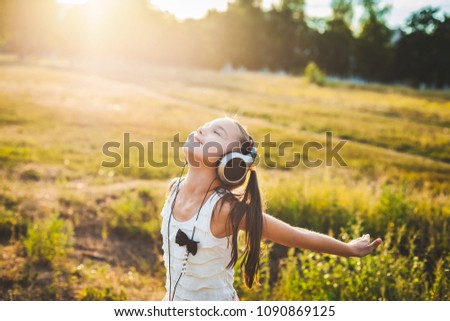 Pretty girl listening music with headphones and having rest, lucky child listening music and resting Royalty-Free Stock Photo #1090869125