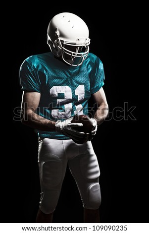 Football Player with number on the uniform, holding a ball. Studio Shot